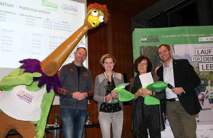 Die Sieger und Best-Platzierten der PaKa-Cup-Wertungen 2017 mit Christian Stork (links, Organisationsleiter Paderborner Osterlauf), Margita Fischer (Mitte, EAM), Moderator Michael Aufenanger (Mitte hinten) und Marathon-Maskottchen Winnie. - Foto: Michael Bald